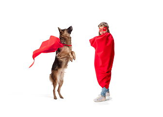 Image showing Child pretending to be a superhero with her super dog isolated on white studio background