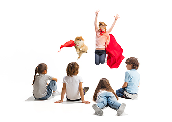 Image showing Child pretending to be a superhero with her super dog and friends sitting around