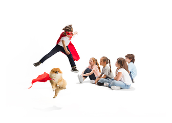 Image showing Child pretending to be a superhero with his super dog and friends sitting around