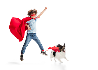 Image showing Child pretending to be a superhero with his super dog isolated on white studio background