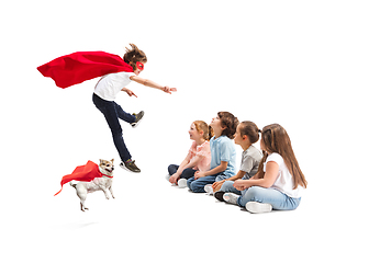 Image showing Child pretending to be a superhero with his super dog and friends sitting around