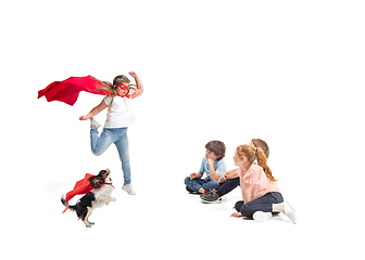 Image showing Child pretending to be a superhero with her super dog and friends sitting around