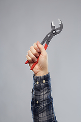 Image showing close up of builder's hand holding wrench