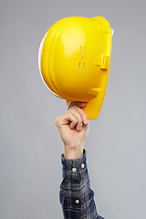 Image showing close up of builder's hand holding helmet