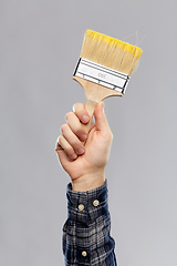 Image showing close up of builder's hand holding paint brush