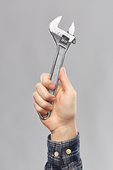 Image showing close up of builder's hand holding wrench