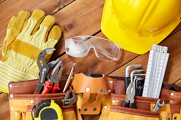 Image showing different work tools in belt on wooden boards