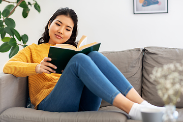 Image showing asian young woman reading book at home