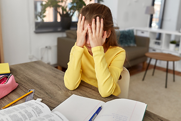 Image showing stressed little student girl learning at home