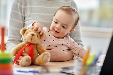 Image showing happy baby with mother working at home office