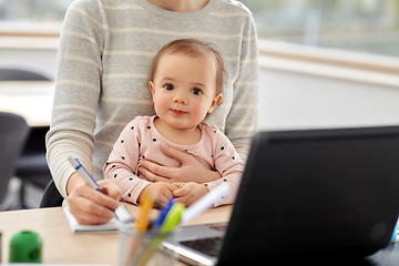 Image showing mother with baby working at home office