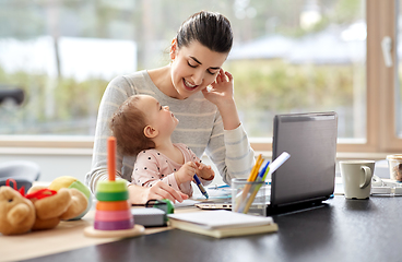 Image showing happy mother with baby working at home office
