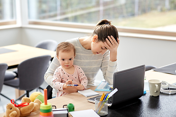 Image showing tired mother with baby working at home office