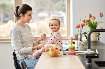 Image showing happy mother with baby working at home office