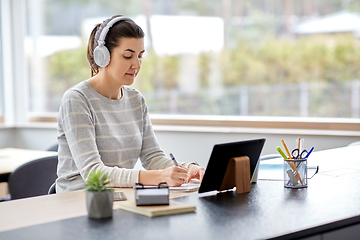 Image showing woman in headphones with tablet pc working at home