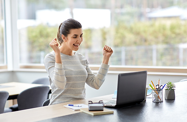 Image showing happy woman with laptop working at home office