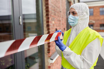 Image showing healthcare worker sealing door with caution tape