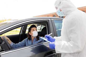 Image showing healthcare worker with clipboard and woman in car