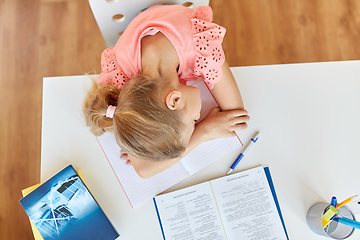 Image showing tired student girl sleeping on table at home