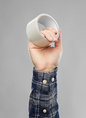 Image showing close up of builder's hand holding adhesive tape