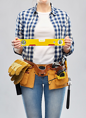 Image showing woman builder with level and working tools on belt