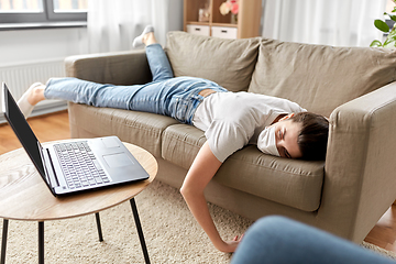 Image showing sick bored woman with laptop lying on sofa at home