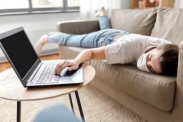 Image showing sick bored woman with laptop lying on sofa at home