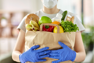 Image showing woman in gloves with food in paper bag at home