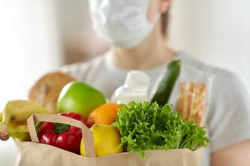 Image showing woman in mask with food in paper bag at home