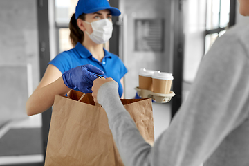 Image showing delivery girl in mask giving paper bag to woman