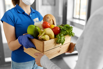 Image showing delivery woman in mask giving food to customer