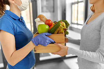 Image showing delivery woman in mask giving food to customer