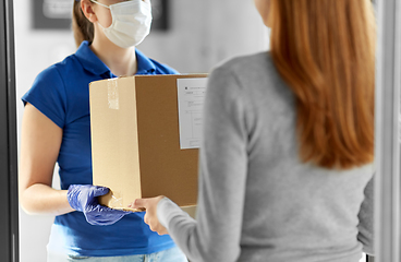 Image showing delivery girl in face mask giving parcel to woman