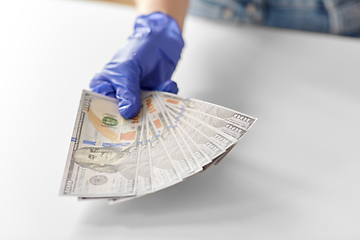 Image showing close up of hand in medical glove holding money