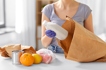 Image showing woman in gloves taking food from paper bag at home
