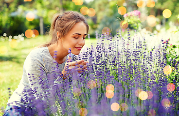 Image showing young woman smelling lavender flowers in garden