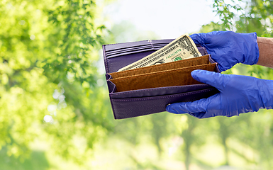 Image showing close up of hands in gloves with dollar in wallet