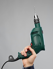 Image showing close up of builder's hand holding drill