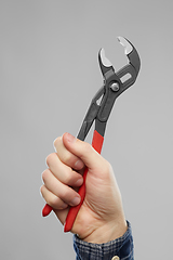 Image showing close up of builder's hand holding wrench