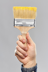 Image showing close up of builder's hand holding paint brush