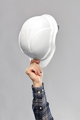 Image showing close up of builder's hand holding helmet