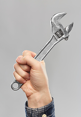 Image showing close up of builder's hand holding wrench