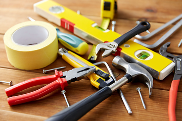 Image showing different work tools on wooden boards background