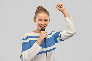 Image showing smiling teenage girl with microphone singing