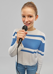 Image showing smiling teenage girl with microphone singing