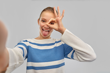 Image showing teenage girl taking selfie and showing tongue