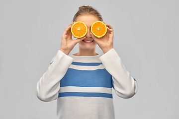 Image showing smiling teenage girl with oranges instead of eyes