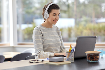 Image showing woman in headphones with laptop working at home