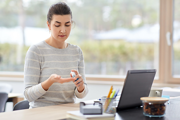 Image showing woman spraying hand sanitizer at home office