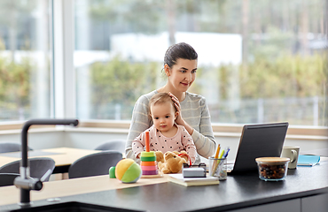 Image showing mother with baby and laptop working at home office